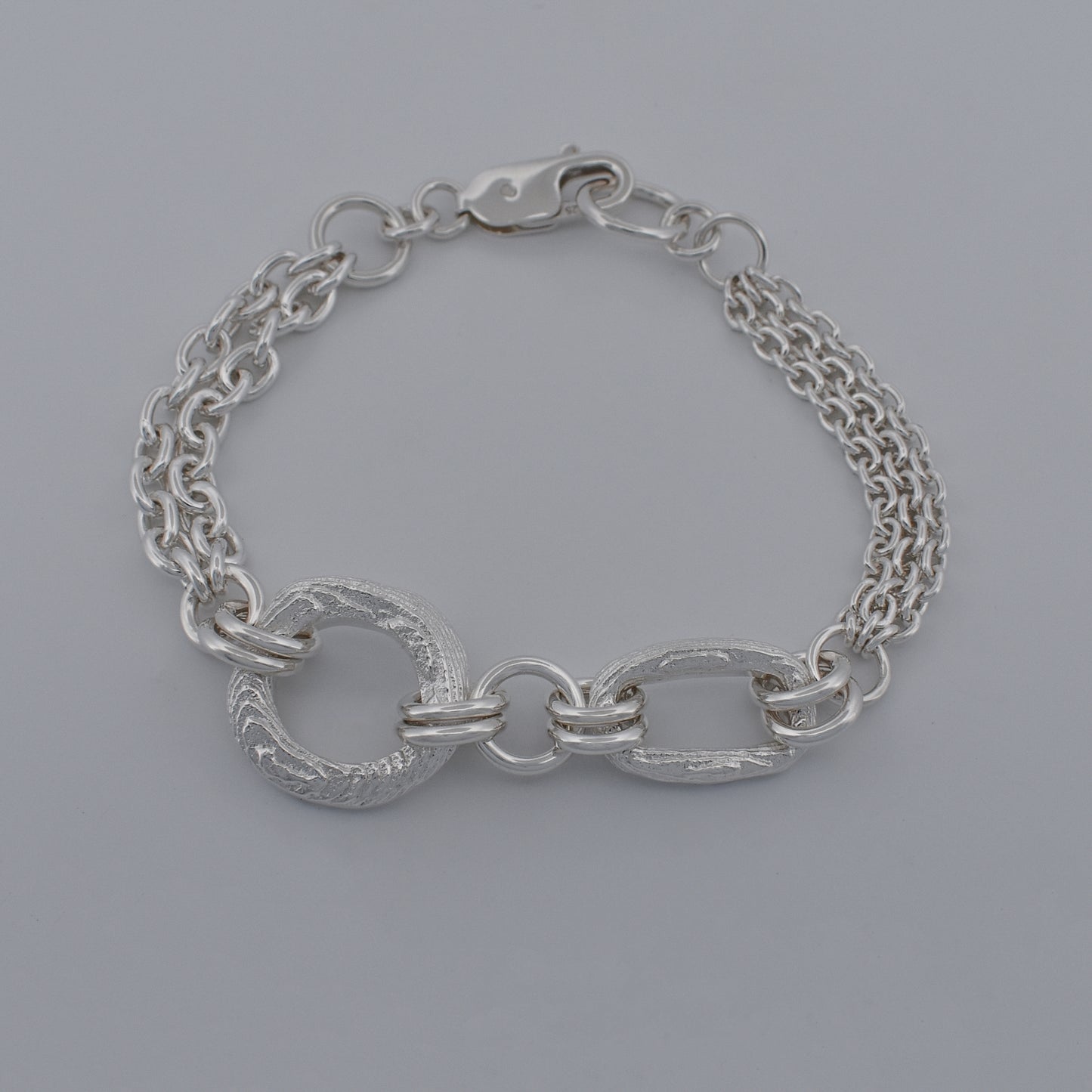 Sterling silver mix‑match chain bracelet with open sculptural textured shapes connected by cable chain