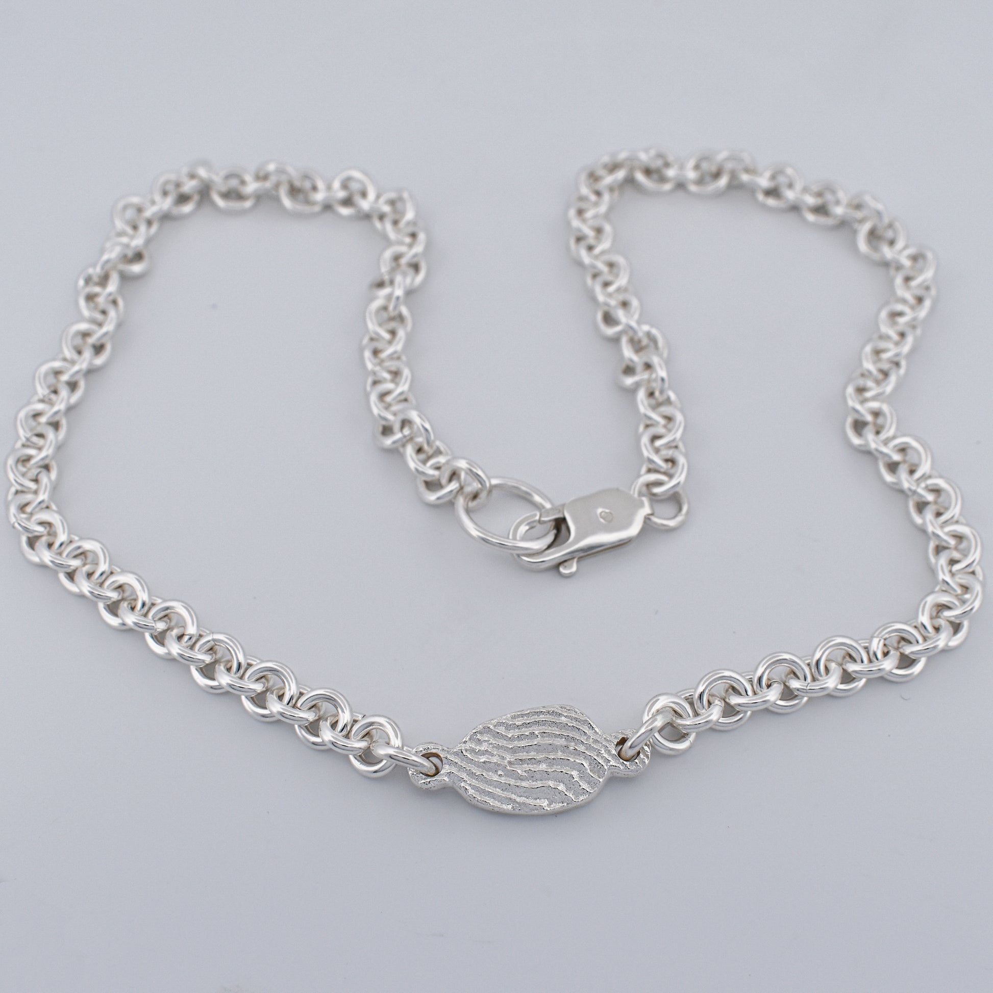 Close up of the tidal tab unisex sterling silver belcher chain necklace