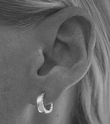 Model wearing textured earrings with polished sides, shown on ear