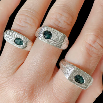 Group shot on hand of three sterling silver signet rings with rose-cut emeralds
