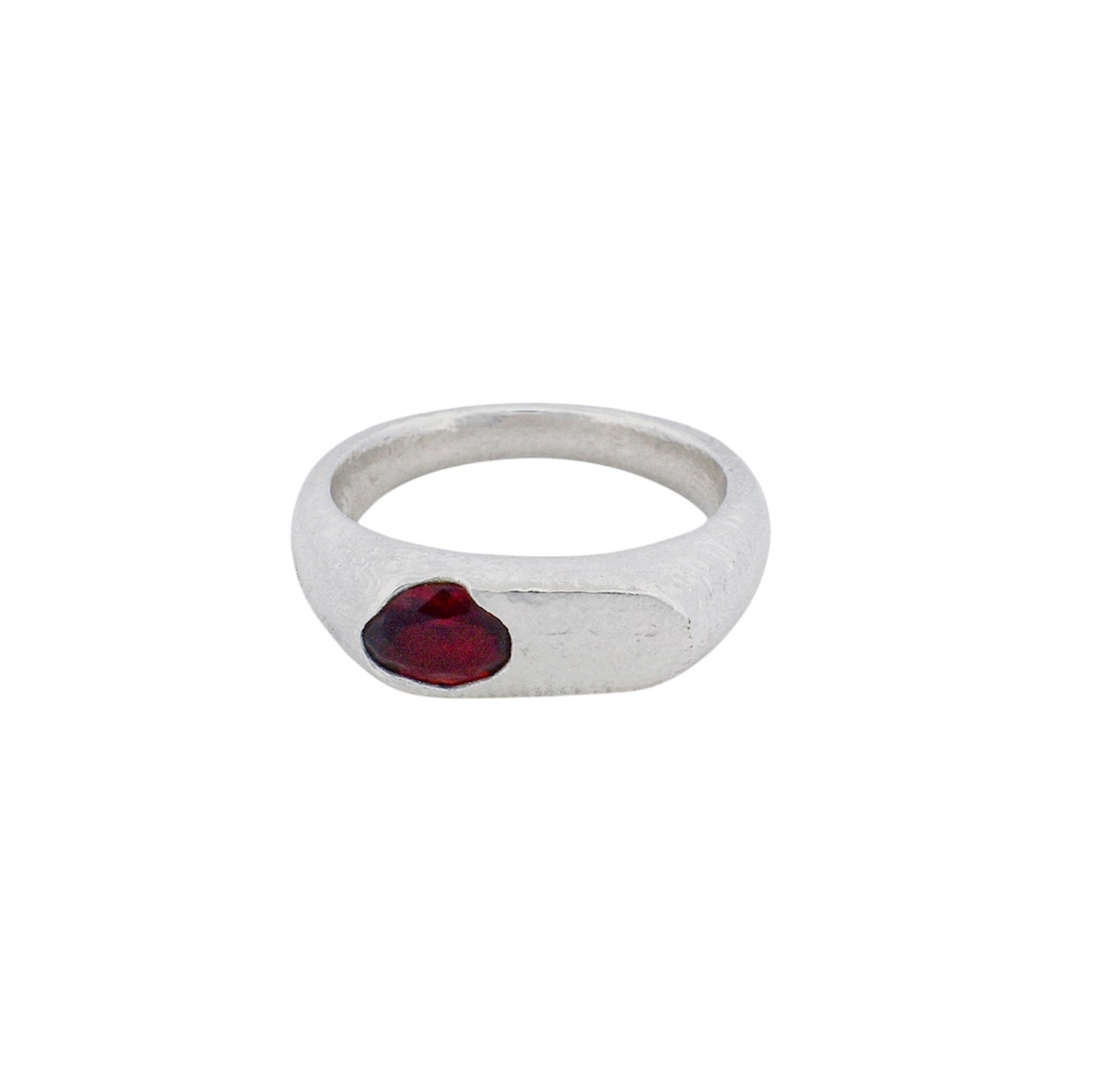 Product shot of an oval signet ring with a garnet gemstone set organically