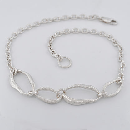 Sterling silver chain necklace featuring four sculptural links with raw textures